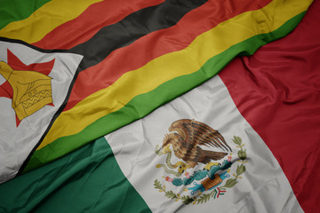 waving colorful flag of mexico and national flag of zimbabwe. macro