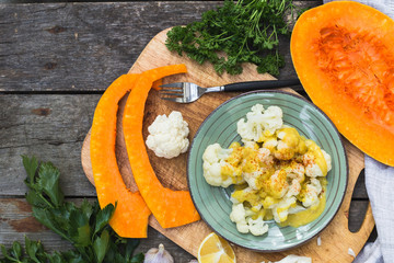 Steamed cauliflower with sauce and pumpkin and greenery