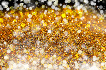 Glitter lights gold or yellow grunge background. Glitter defocused abstract Twinkly Lights and Stars Christmas Background