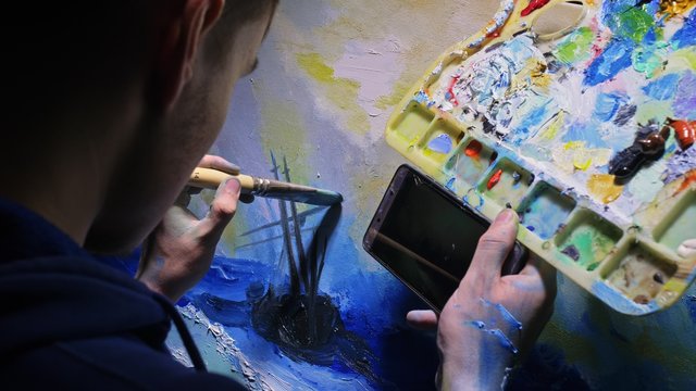 Artist copyist paint seascape with ship in ocean. Craftsman decorator draw as boat sail on blue sea. In hand of cellphone tablet computer pc.