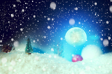 Fairy tale Christmas background with Christmas balls on snow over fir-tree, night sky and moon. Shallow depth of field. The elements of this image furnished by NASA