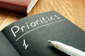 Priorities list in the black notepad. - obrazy, fototapety, plakaty