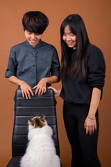 Young Asian lesbian couple together and in love against brown ba