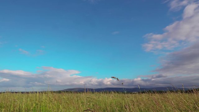 timelapse of clouds passing over a field with blue sky and mountains