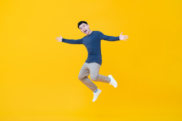 Fototapeta na wymiar Asian man smiling and jumping with arms outstretched