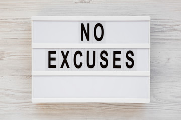 'No excuses' words on a modern board on a white wooden surface, top view. Overhead, from above, flat lay.