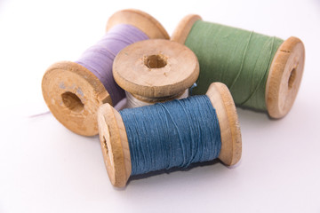 green blue purple white sewing thread on white background isolated