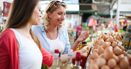 Women shopping fresh eggs at local farmer market