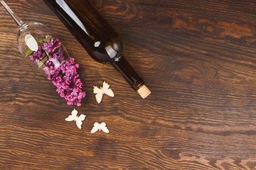 Fototapeta na wymiar Wineglass with lilacs and butterflies