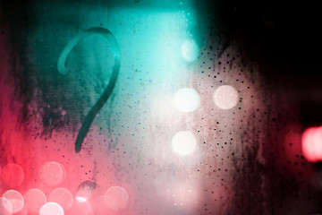 a question mark on the fogged glass. question on the glass at night
