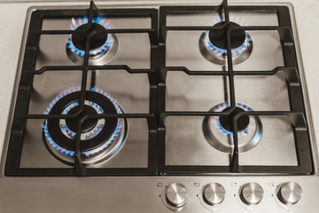 kitchen gas stove with burning propane gas fire. Close-up shot of blue fire from home kitchen...