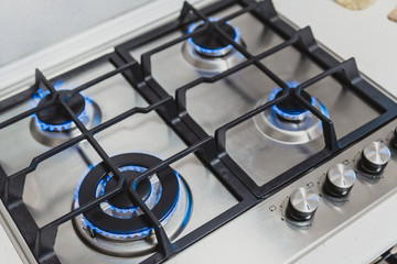 kitchen gas stove with burning propane gas fire. Close-up shot of blue fire from home kitchen...