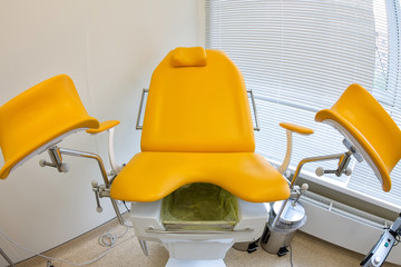 Interior gynecological office with an orange chair in a medical clinic