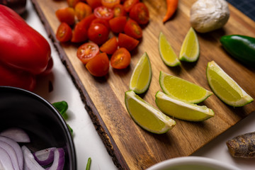 Close up of a cutting board with  a selection of healthy vegetables and fruit on a wooden cutting board