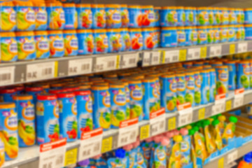 Defocused background, baby food supermarket shelves, fruit puree and porridge for feeding small children, blurred backdrop