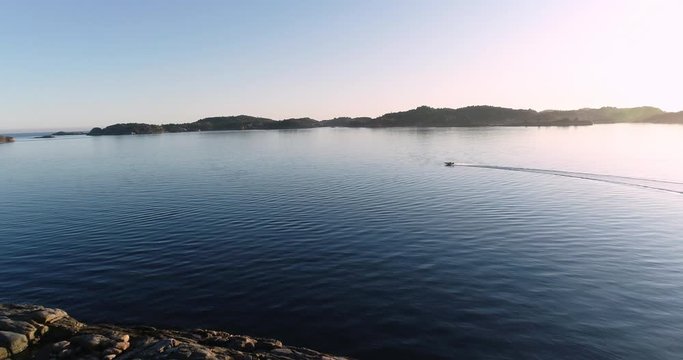 Aerial footage of speed booat crossing peaceful blue water near bautiful island. 