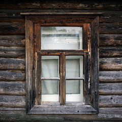 Old window in a country house. The texture of the logs. Rustic background