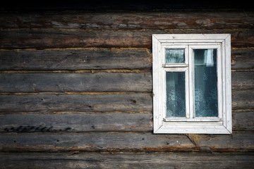 Old window in a country house. The texture of the logs. Rustic background.