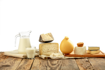 Different milk products, cheese, cream, milk on wooden table and white background. Healthy eating and lifestyle, organic natural nutrition, diet. Delicious food and drinks.