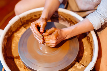 man sculpts from clay in a workshop on a lathe