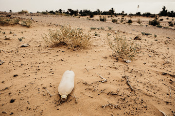 Plastic bottle abandoned in the sand. Contamination.