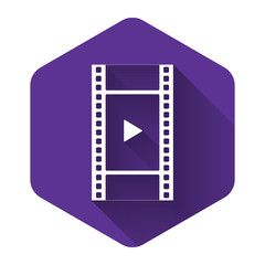 White Play Video icon isolated with long shadow. Film strip with play sign. Purple hexagon button. Vector Illustration