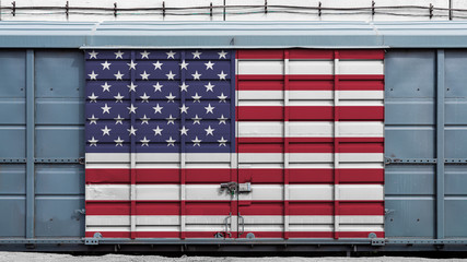 Front view of a container train freight car with a large metal lock with the national flag of USA.The concept of export-import,transportation, national delivery of goods and rail transportation