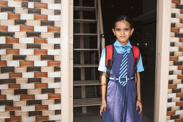 A young girl ready with uniform - small kid leaving home for school - Concept of back to school and...