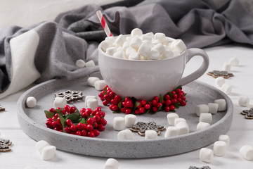 Christmas hot chocolate or coffee with marshmallow on white wooden table with christmas decorations