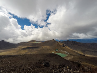 Landscape view of colorful Emerald lakes and volcanic landscape with hikers walking by, Tongariro national park, New Zealand