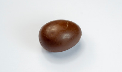 Chocolate egg. A broken, exploded eggshell, two halves, and a whole chicken egg. A sweet symbol of Easter,a dessert of dark cocoa, the design of the celebration.
