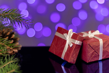 gift boxes red with white bow on wooden table new year festive mood atmosphere bokeh blurred background lights