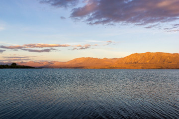Beautiful Lake Tekapo with mountain range in the Background on sunset with clouds, South Island, New Zealand