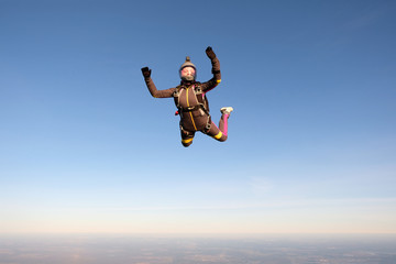 Fototapeta na wymiar Skydiving. An active woman is flying in the sky.