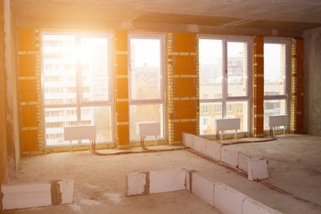 huge space of a new luxury modern apartment with floor-to-ceiling windows in an apartment building under construction