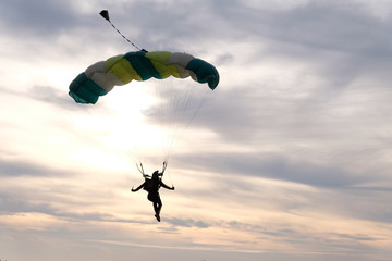 Skydiving. A parachute is in the sunset sky. - obrazy, fototapety, plakaty