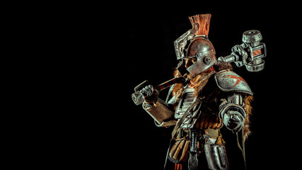 Powerful knight in the armor with the hammer. Dark background.