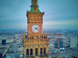 Fototapeta premium Beautiful panoramic aerial close-up drone view to the Millennium clock (clock face diameter = 6.5 m) on the tower of PKiN and cityscape of Warsaw modern City, Poland