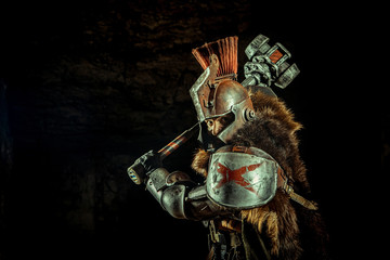 Attack of a powerful knight in the armor with the hammer. Dungeon on the background.