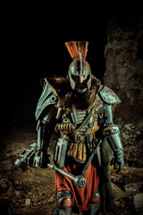 Powerful knight in the armor with the hammer. Dungeon on the background.