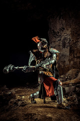 Attack of a powerful knight in the armor with the hammer. Dungeon on the background.