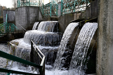 Photo of a waterfall. Autumn park on the shore. Image of nature, forest, landscape.