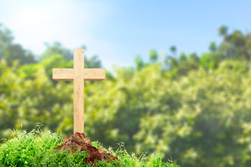 Christian cross on the ground with green grass