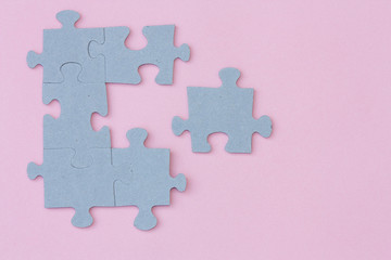 Puzzle pieces on light pink background.