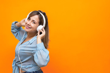 Young girl smiling, dancing, and listening to music with headphones