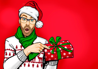 Amazed bearded man in glasses  and Santa hat with open mouth showing gift box. Emotions and advertisement. Surprised men. Christmas