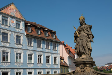 Fototapeta na wymiar Bamberg, Germany - July 15, 2019; Statue of Queen Kunigunda on the Alte Rathaus bridge in Bamberg on a blue sky on a sunny day