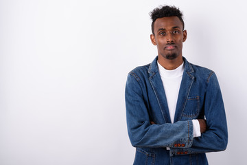 Young bearded African man wearing denim jacket against white bac