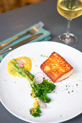 Salmon steak fillet and garnished with young broccoli. Restaurant menu, a series of photos of different dishes