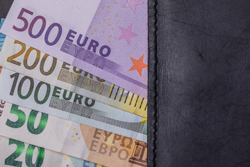 Obraz premium Euro banknotes next to the wallet in black